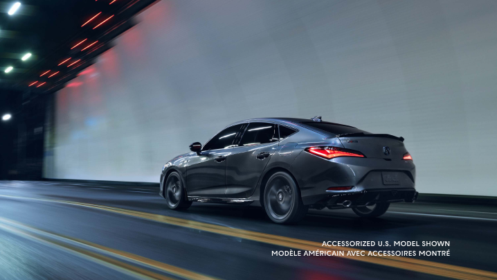 Vue du quart arrière gauche de l’Integra qui roule sur une route dans un tunnel la nuit avec les feux arrière à DEL allumés.